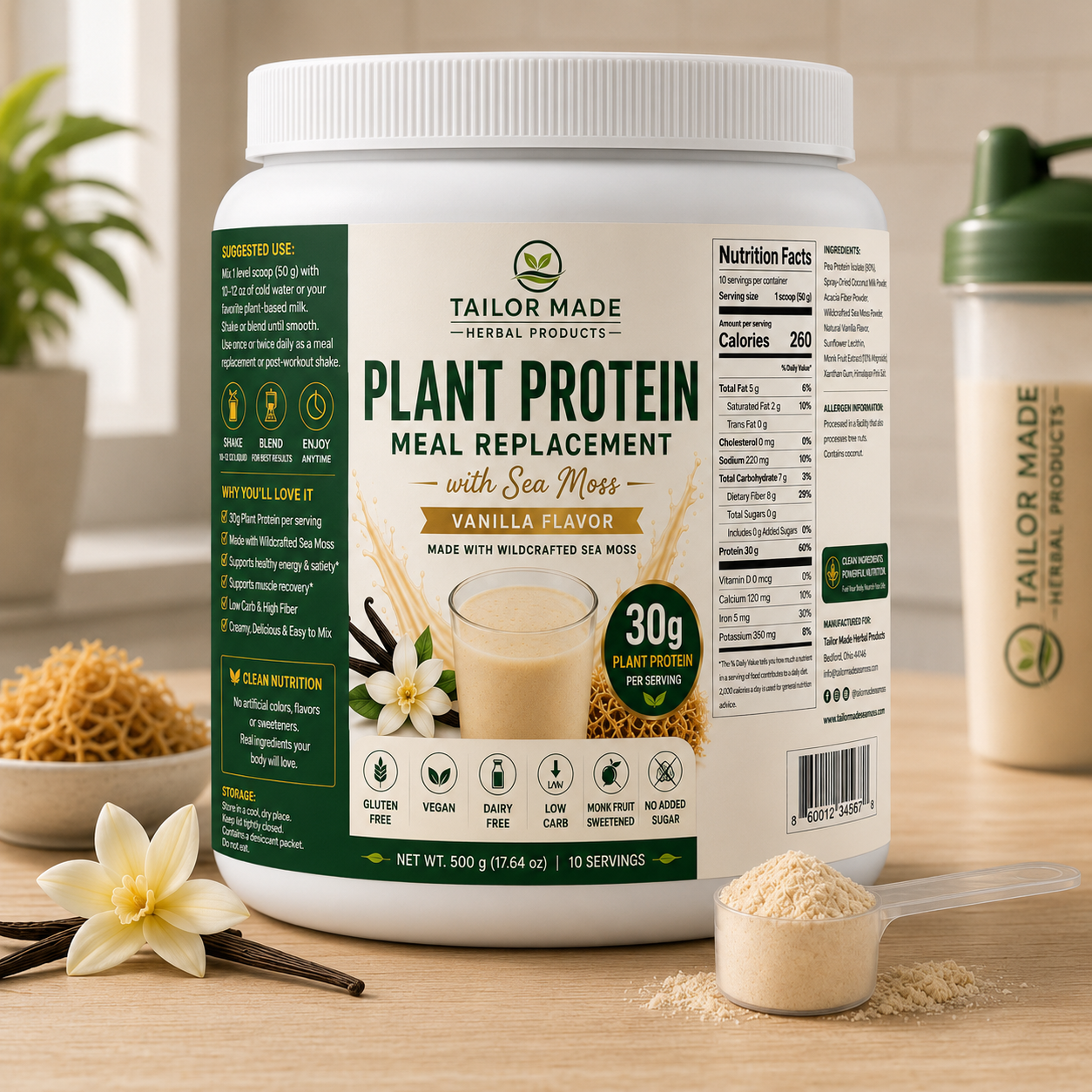 A large white tub of Tailor Made Herbal Products Plant Protein Meal Replacement in Vanilla Flavor with Sea Moss, shown on a wooden surface with a scoop of powder, vanilla flower, and whole ingredients in the background.