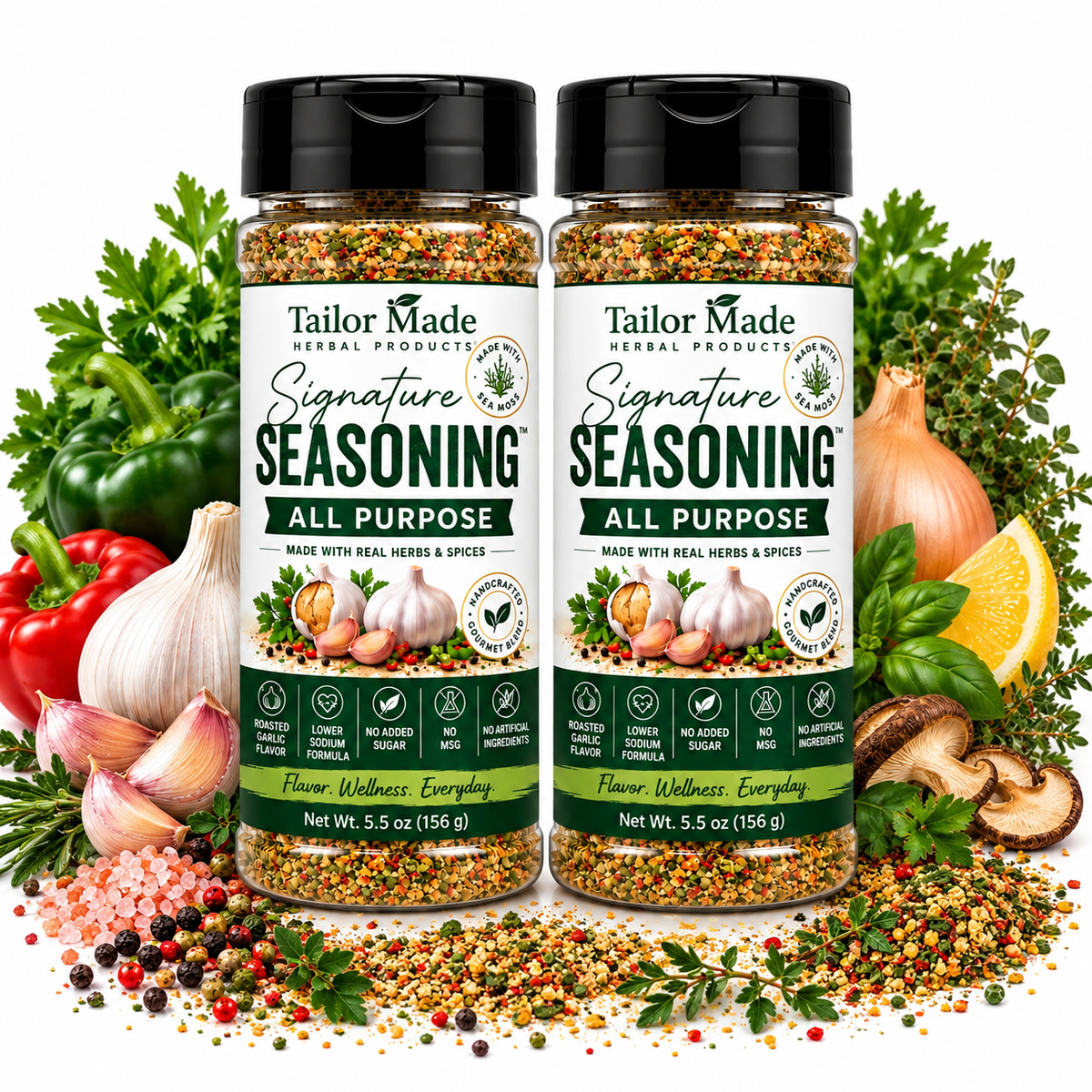 Two bottles of Tailor Made Herbal Products Signature Seasoning All Purpose, surrounded by fresh ingredients including garlic, red bell pepper, parsley, onion, lemon, mushrooms, and peppercorns on a white background.