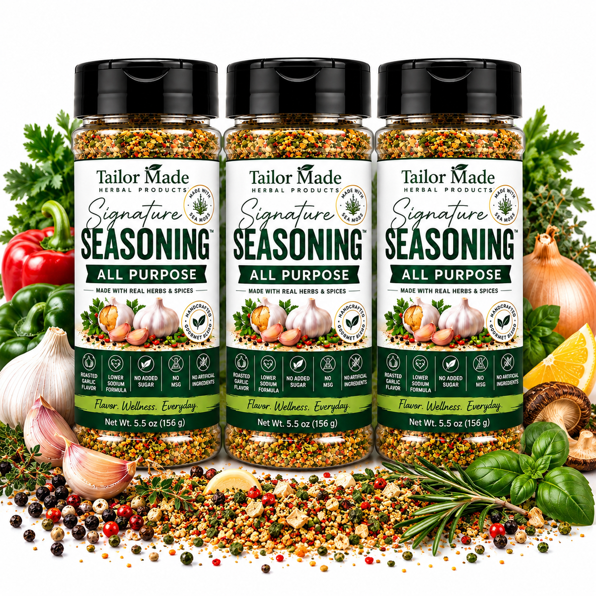 Three bottles of Tailor Made Signature Seasoning All Purpose arranged together with various whole spices, garlic, onions, parsley, and rosemary on a white background.