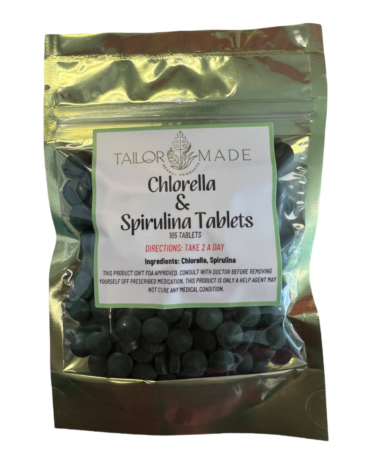 A stand-up pouch of Tailor Made Chlorella & Spirulina Tablets, showing dark green tablets inside a metallic gold translucent bag with a white label.